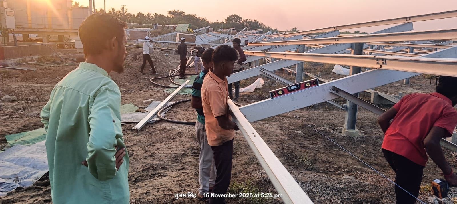 Wide view of solar panel rows across the Gadewadi solar farm at sunset