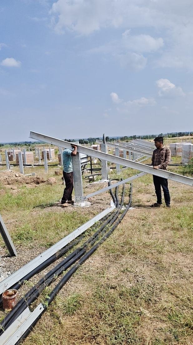 Rows of solar panels running through open farmland at Gadewadi
